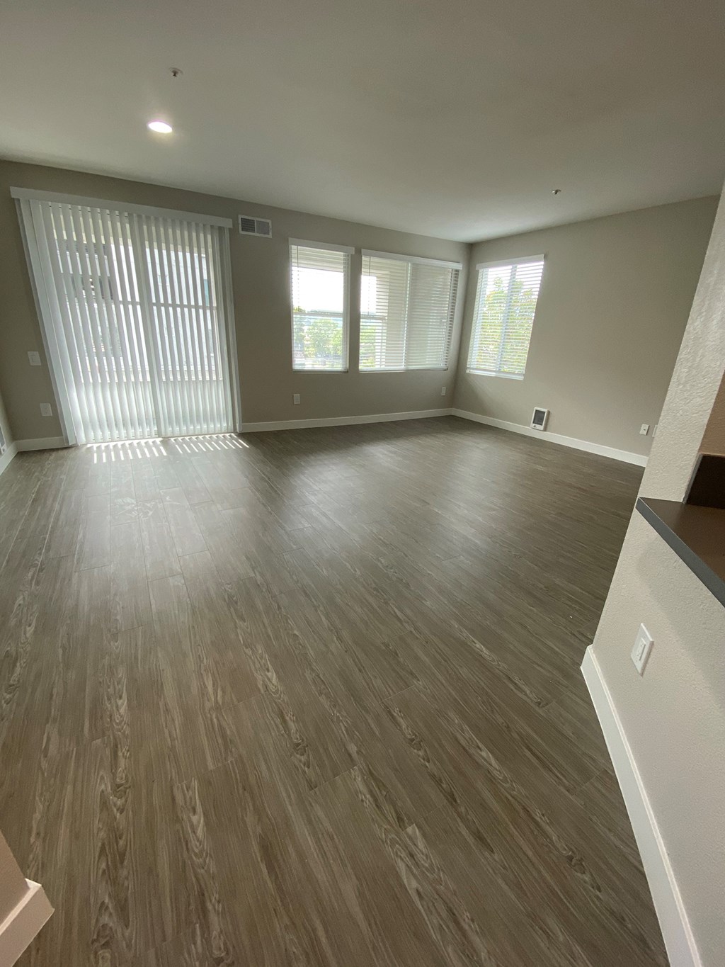 an empty living room with wood floors and windows