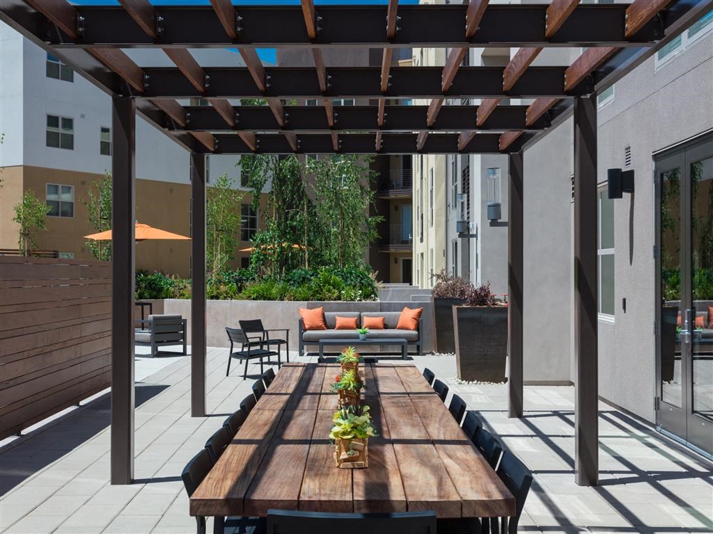 a long dining table under a pergola on a patio