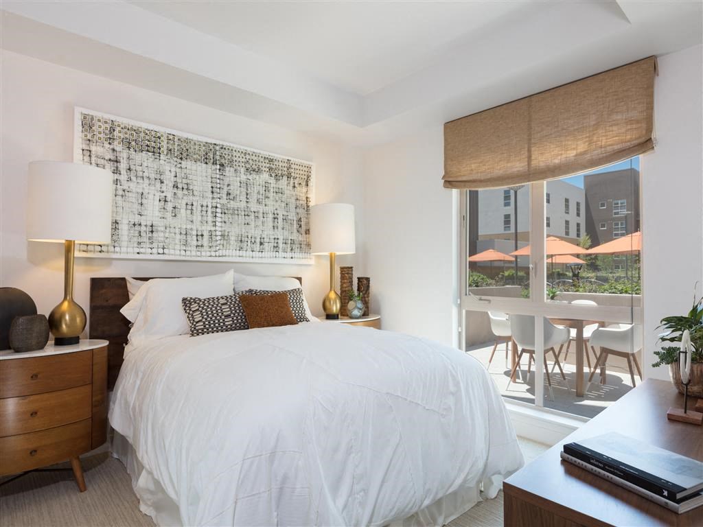 a white bedroom with a large bed and a window