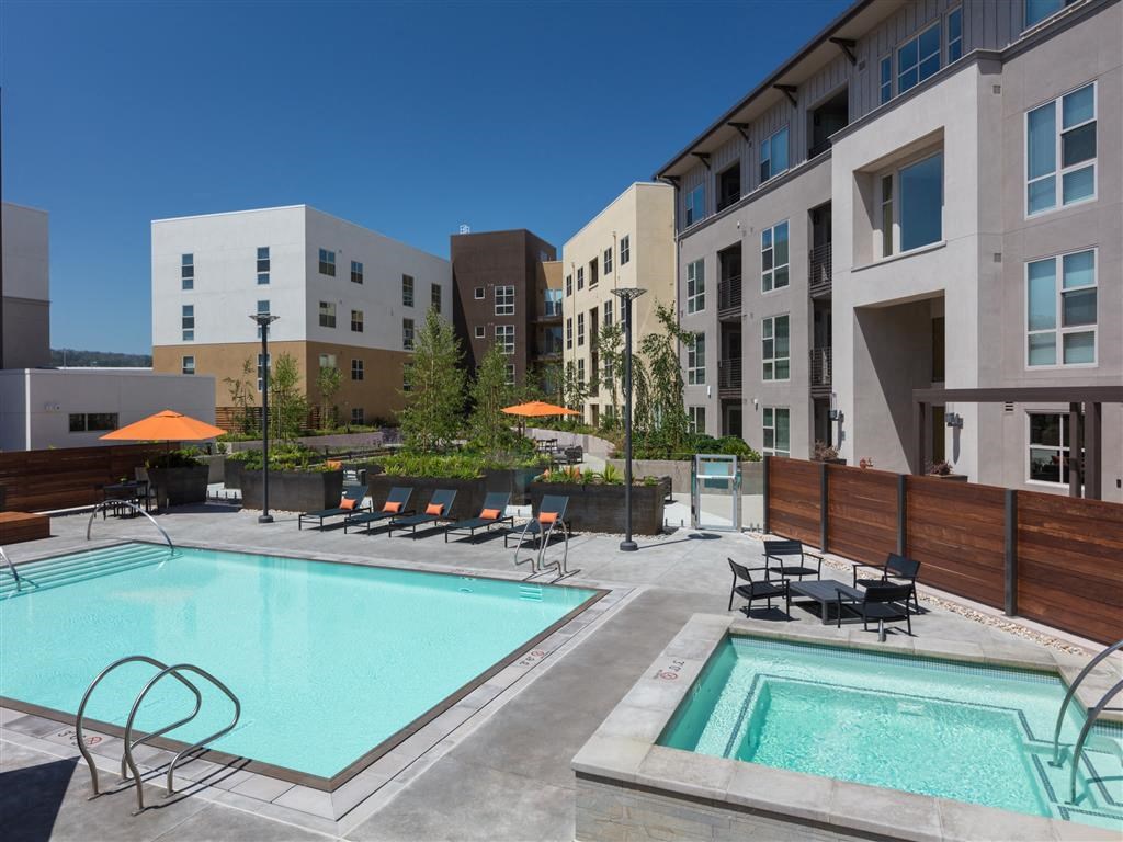 our apartments have a pool and a large patio with chairs and umbrellas