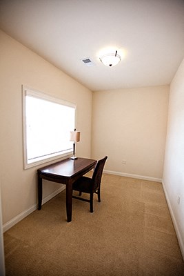 an empty room with a desk and a window