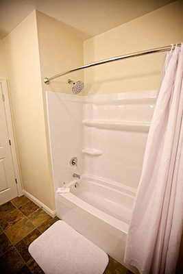 a bathroom with a shower and a white shower curtain
