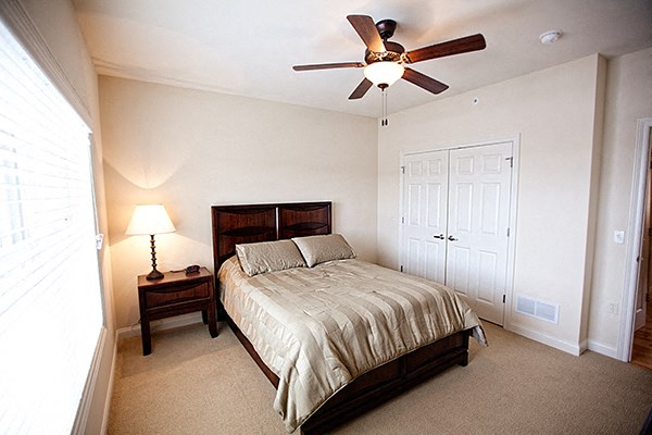 a bedroom with a bed and a ceiling fan
