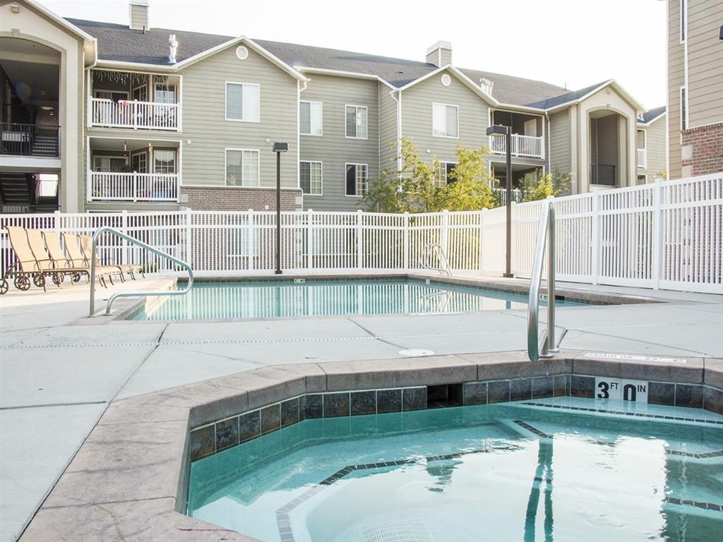 a swimming pool with an apartment building in the background
