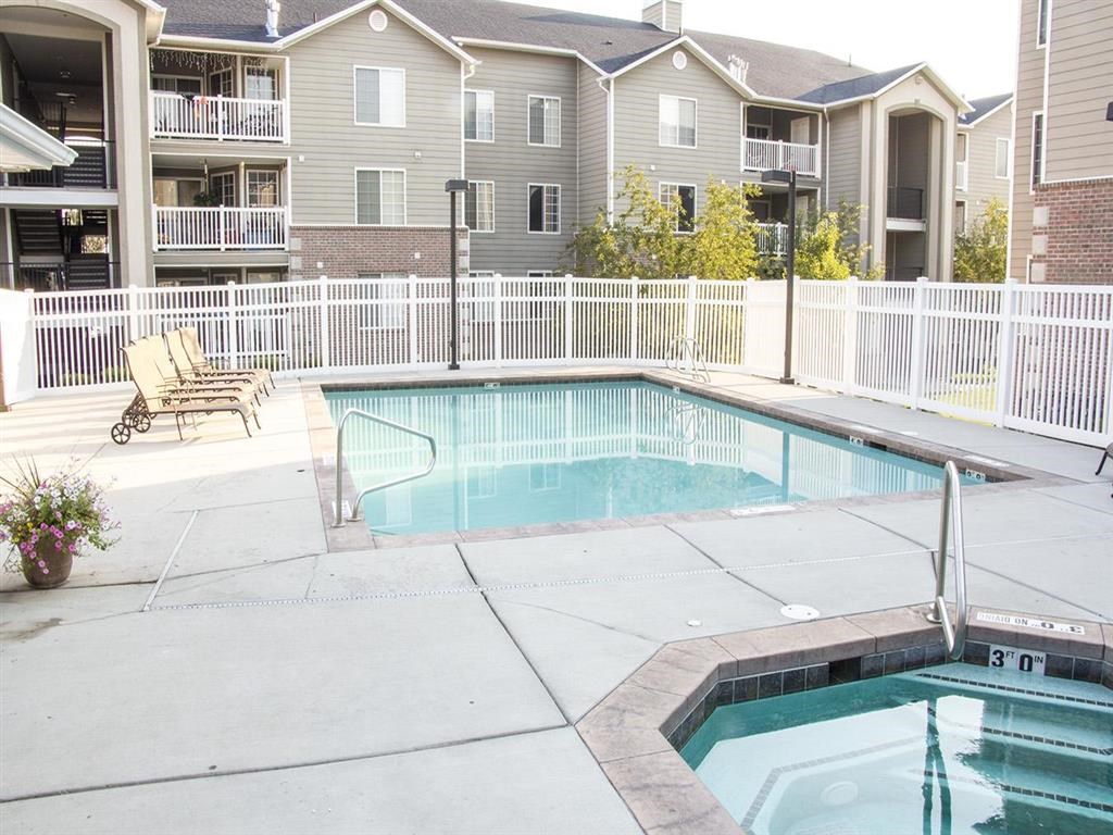 a swimming pool with an apartment building in the background