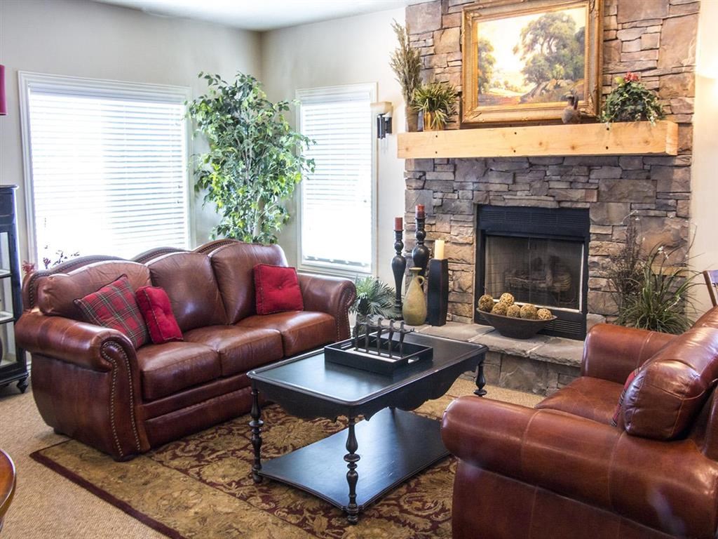 a living room with leather furniture and a fireplace