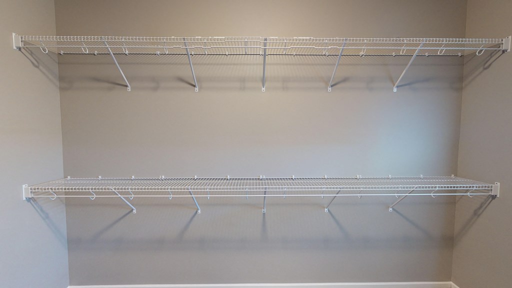 a wire shelf hanging from a wall in a closet