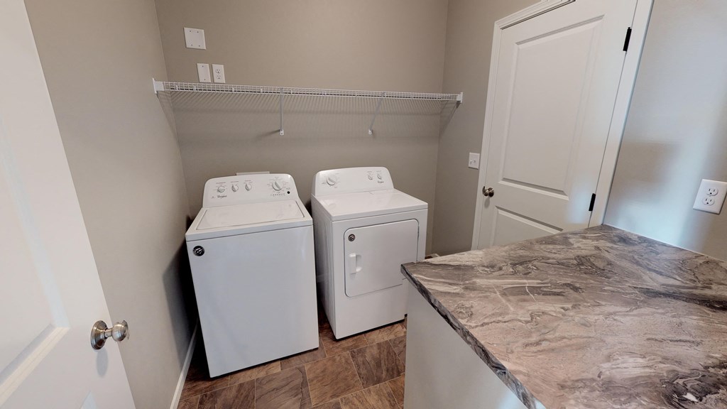 a washer and dryer in a laundry room with a marble counter top