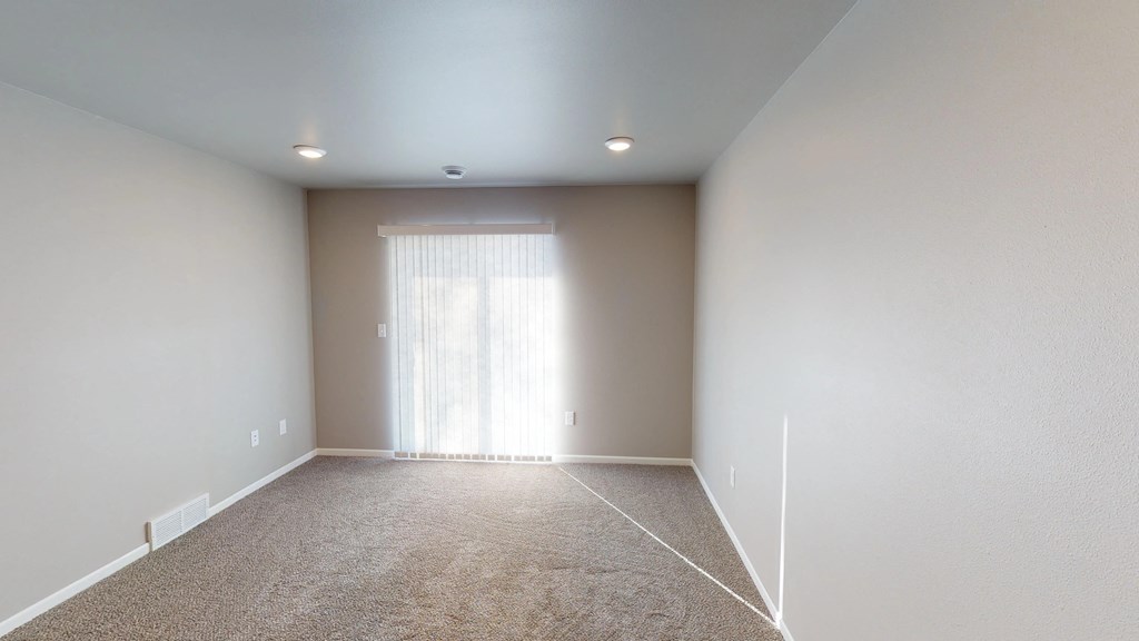 an empty room with white walls and a window