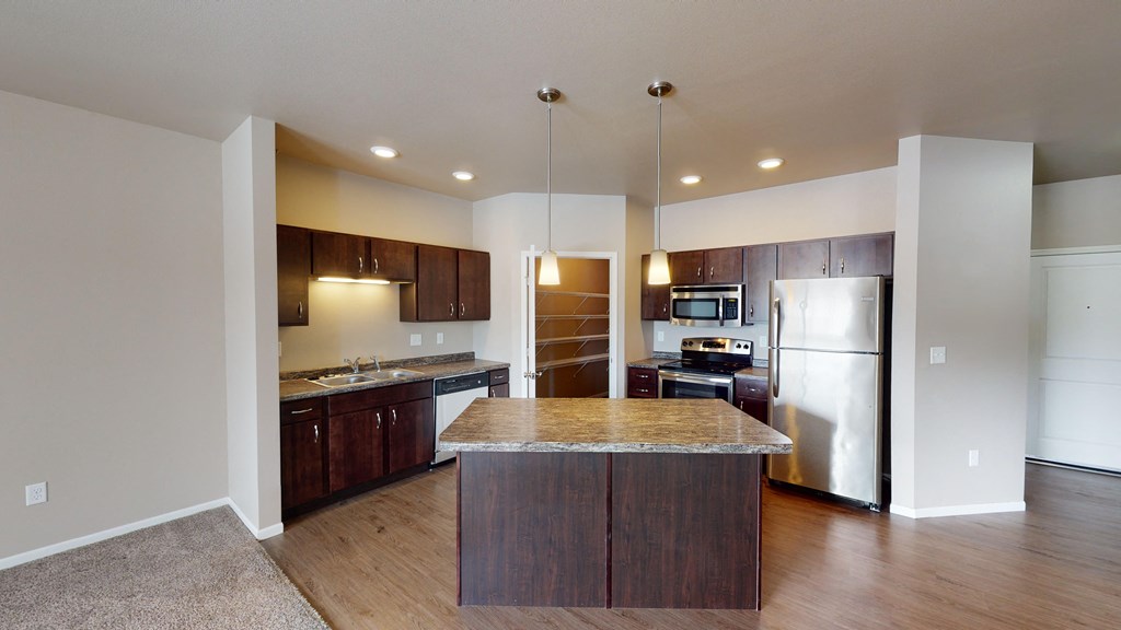 a kitchen with stainless steel appliances and a marble counter top