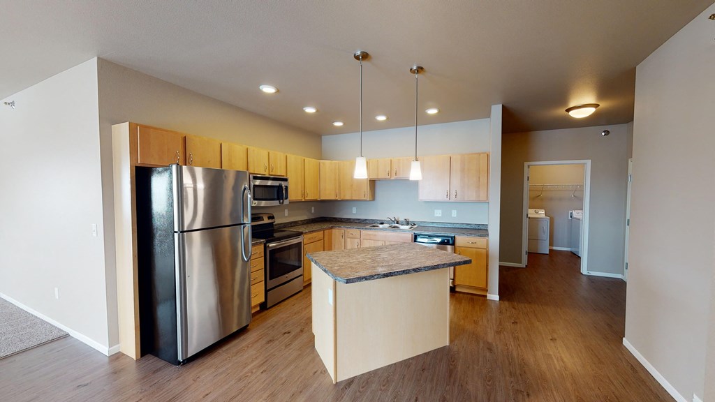 a large kitchen with stainless steel appliances and wooden cabinets