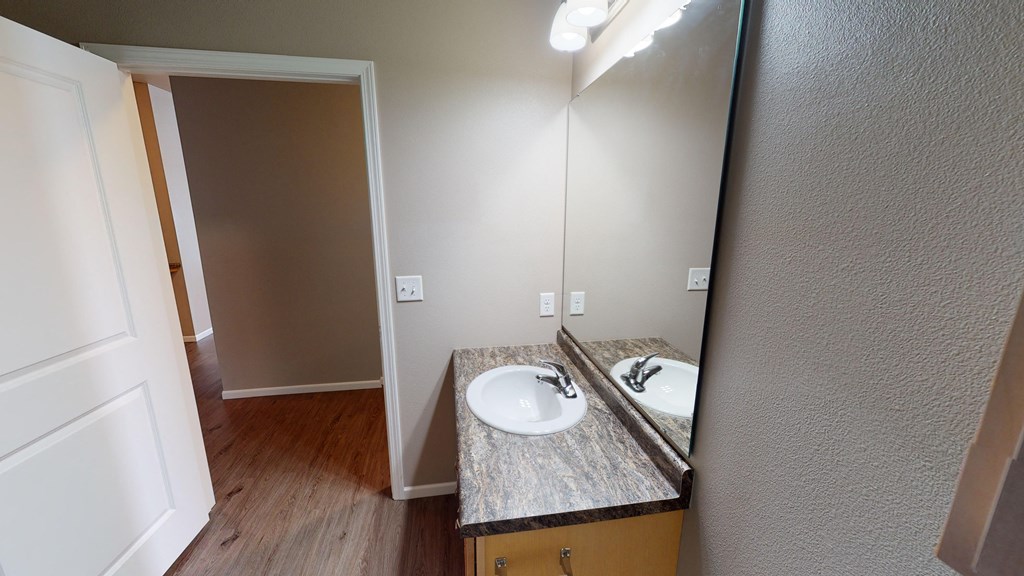 an empty bathroom with a sink and a mirror