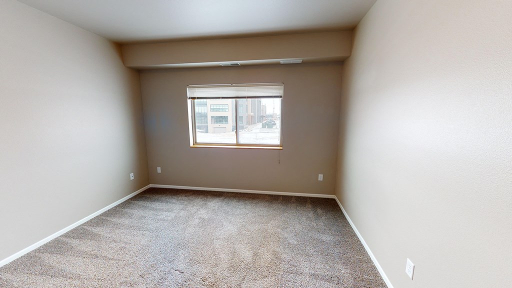 an empty room with carpet and a window