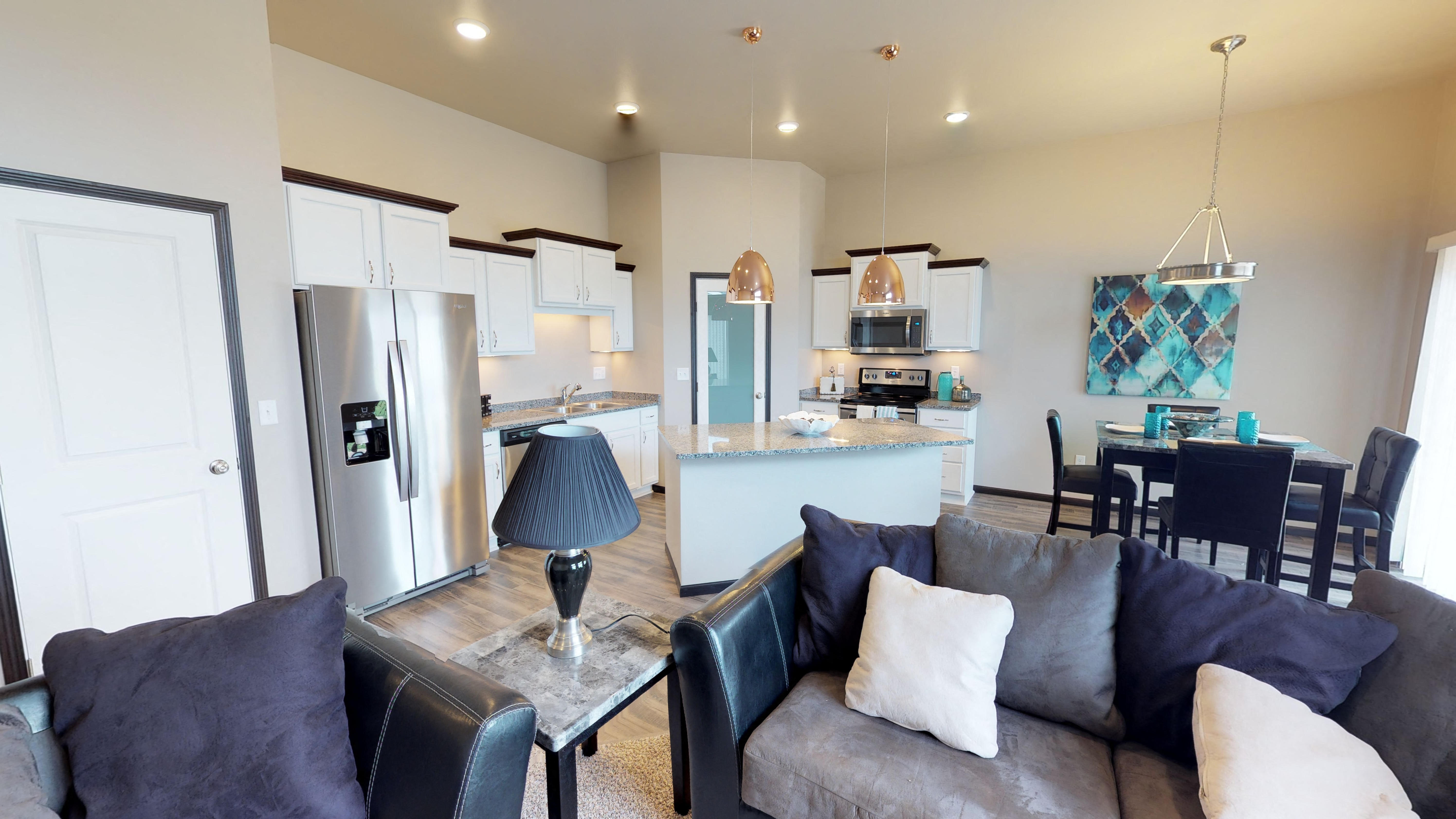 a living room and kitchen with a couch and a table