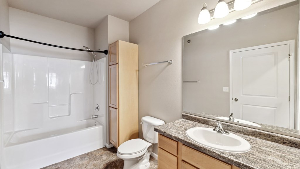 A bathroom with a toilet, sink, and bathtub.