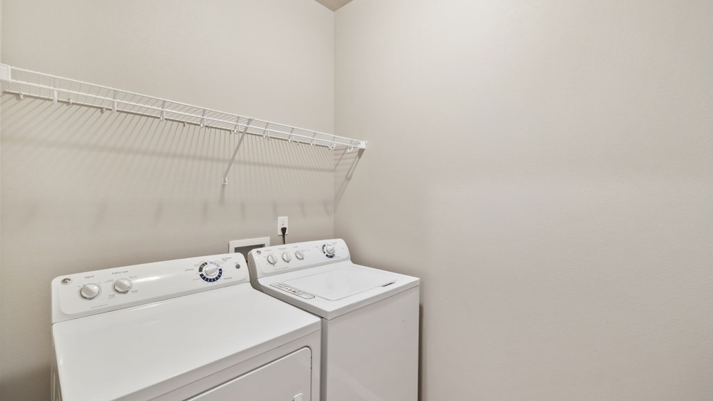A white washing machine and dryer in a laundry room.