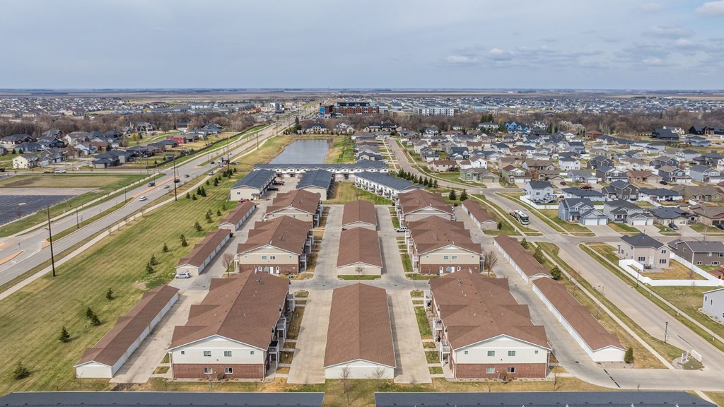A suburban neighborhood with rows of houses and a road running through the middle.