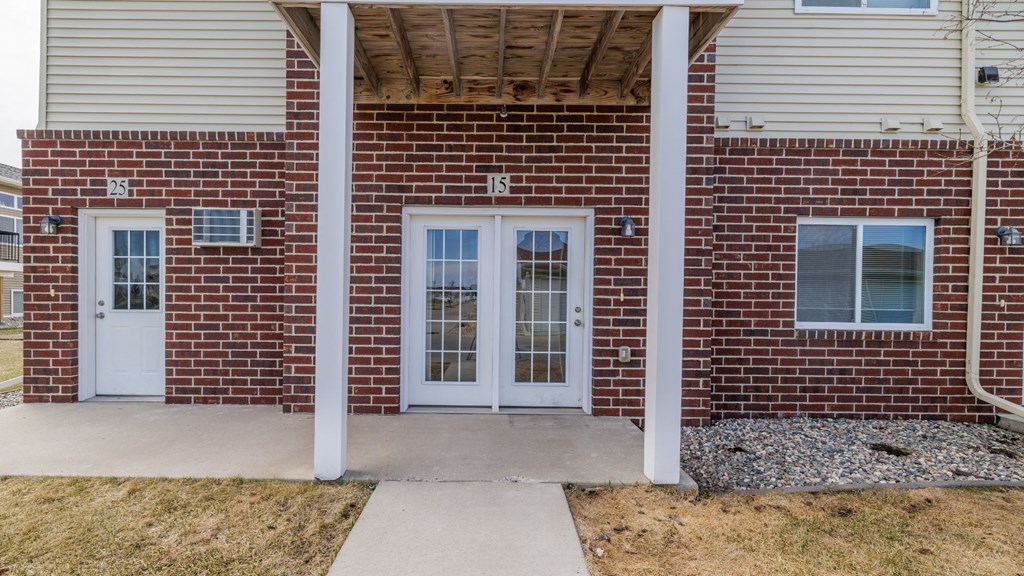 A brick building with a white door and windows.