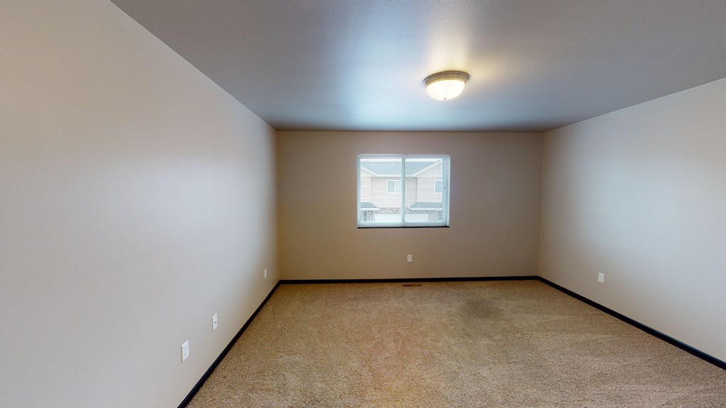 an empty room with carpet and a window