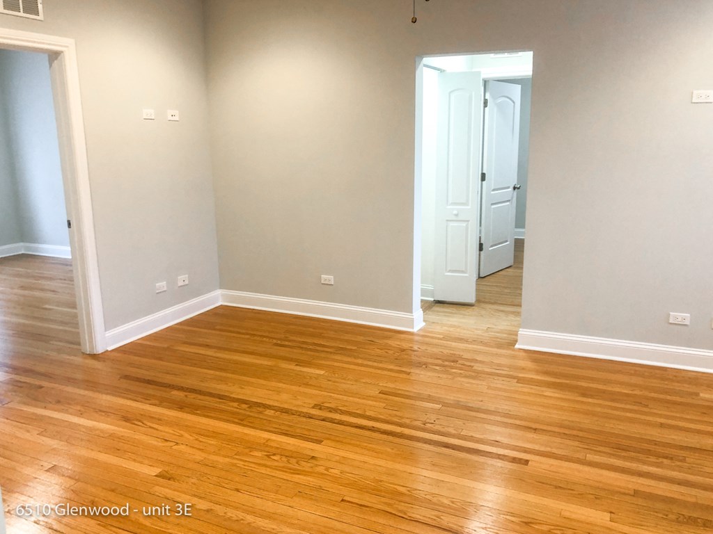 a living room with wooden floors and a white door