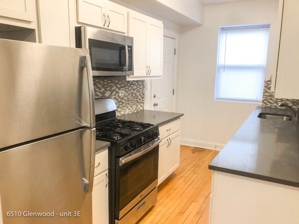 a kitchen with stainless steel appliances and white cabinets