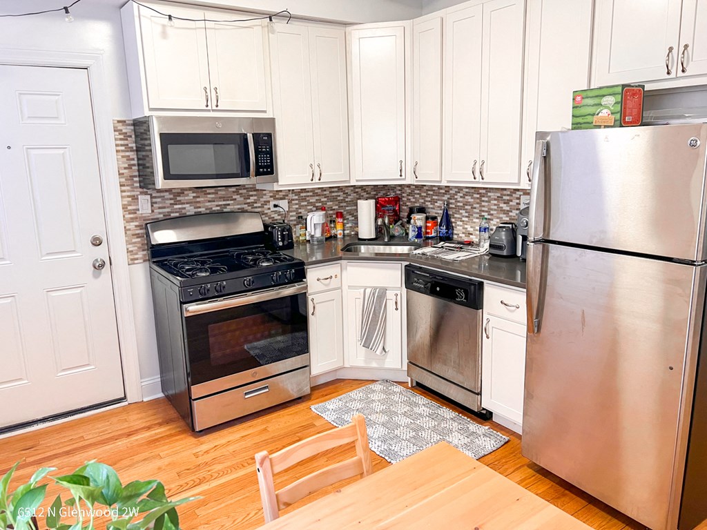 a kitchen with stainless steel appliances and white cabinets