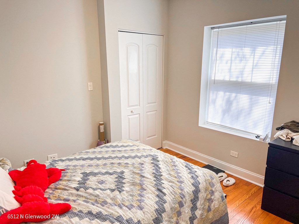 a bedroom with a bed and a stuffed red teddy bear