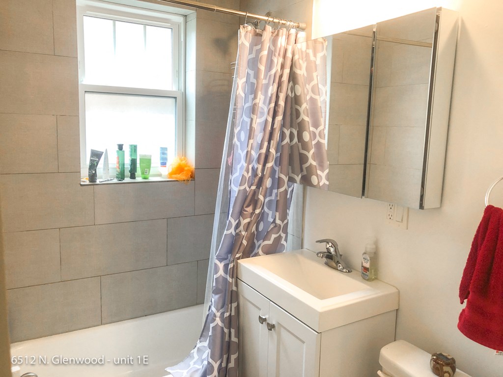a white bathroom with a shower curtain and a sink