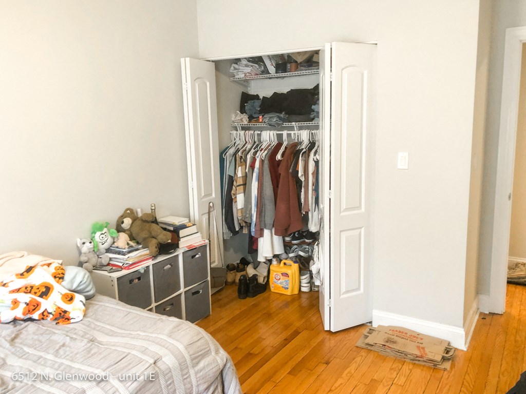 a bedroom with a closet full of clothes and a bed