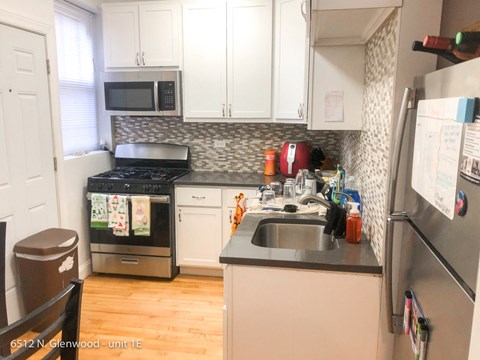 a small kitchen with white cabinets and a sink
