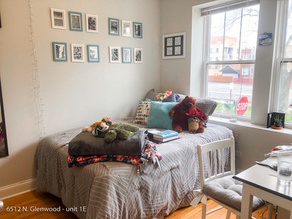 a bedroom with a bed with pillows and stuffed animals on it