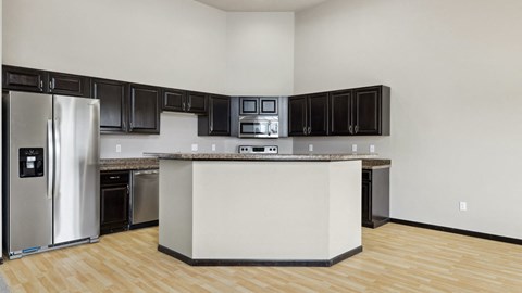 A kitchen with black cabinets and a white island.