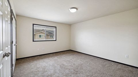 A room with a carpeted floor and a picture frame on the wall.