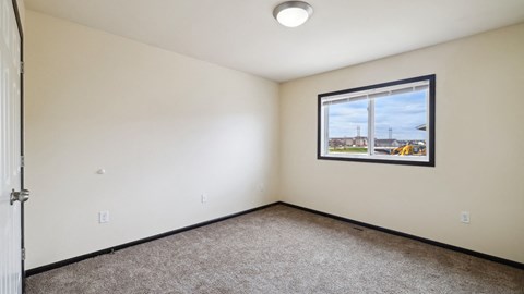 A room with a window and a picture on the wall.