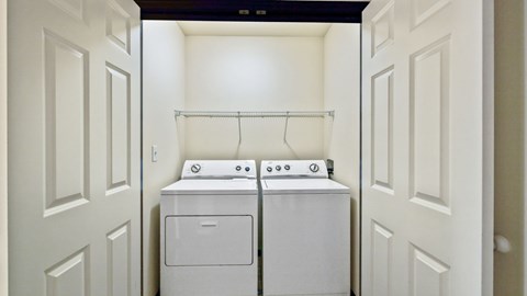 A white washing machine and dryer in a small laundry room.