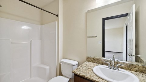 A white toilet sits next to a sink in a bathroom.