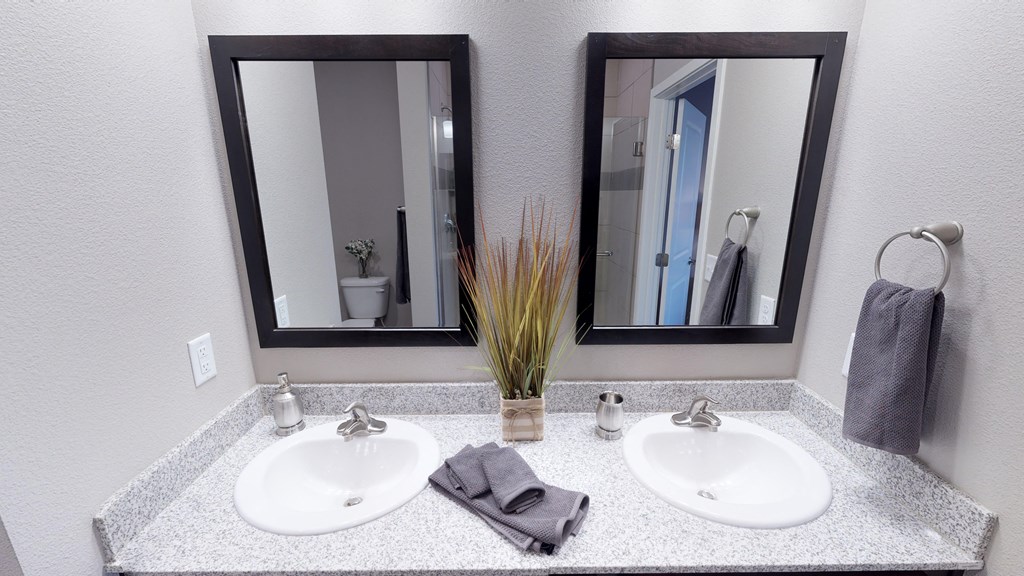 a bathroom with two sinks and two mirrors