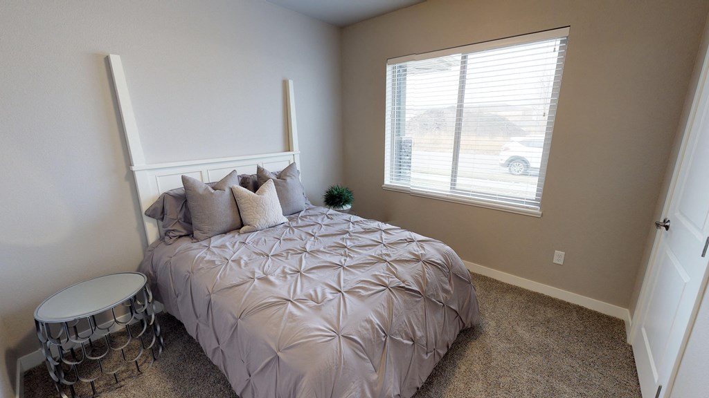 an empty bedroom with a bed and a window