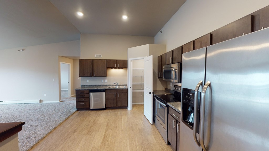 a kitchen with stainless steel appliances and wood flooring
