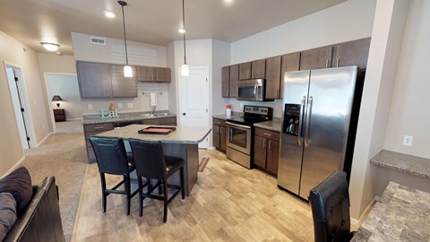 a kitchen with stainless steel appliances and a island with chairs