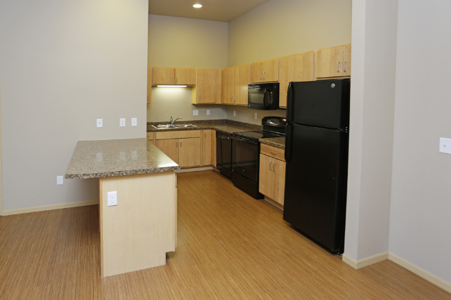 a kitchen with black appliances and a granite counter top