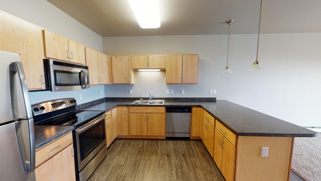 an empty kitchen with wooden cabinets and stainless steel appliances