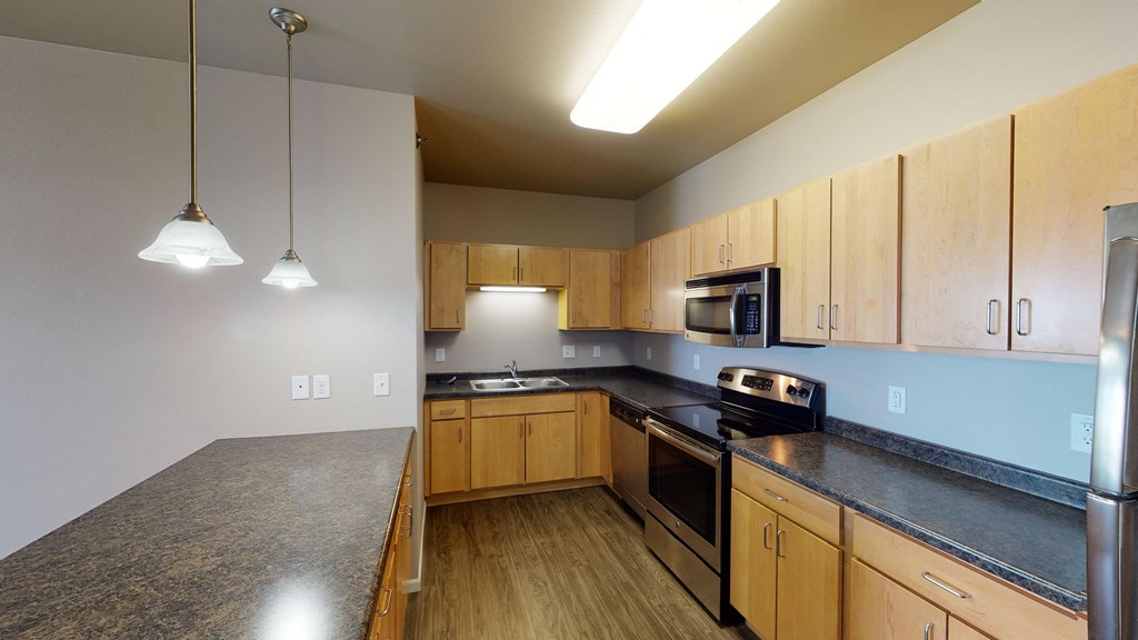 a kitchen with granite counter tops and wooden cabinets