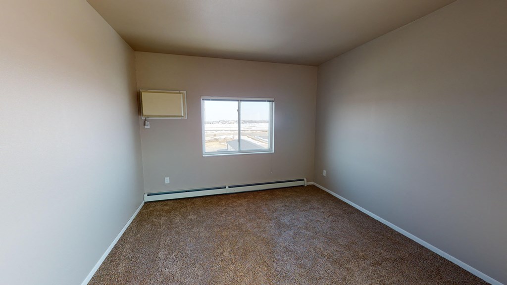an empty room with carpet and a window