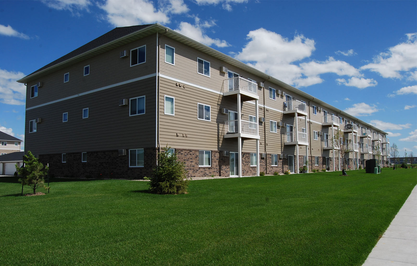 an apartment building with green grass in front of it