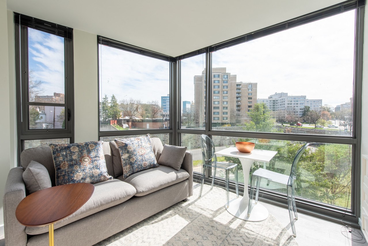 a living room with large windows and a couch and a table
