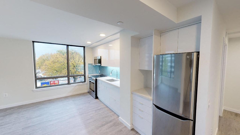 a kitchen with a stainless steel refrigerator and a window