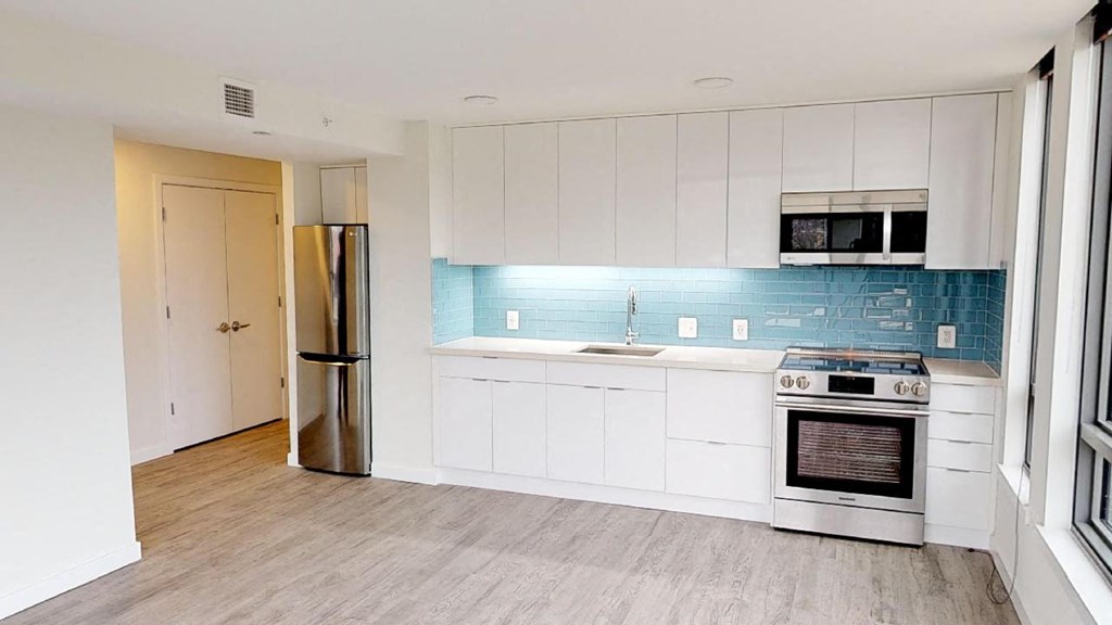 a white kitchen with a stove and a refrigerator