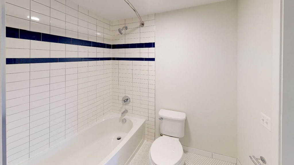 a white bathroom with a tub and a toilet