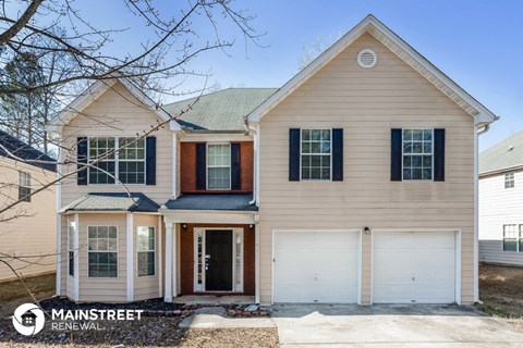 a tan house with a white garage door